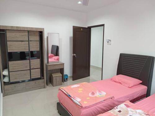 a bedroom with a pink bed and a mirror at EMERALD VILLA HOMESTAY DUNGUN in Batu Lima