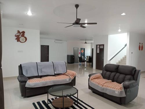 two chairs and a couch in a living room at EMERALD VILLA HOMESTAY DUNGUN in Batu Lima