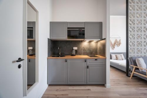 a kitchen with gray cabinets and a bed in a room at A62 - Akácfa Street Central Residence - Best Location by BQA in Budapest