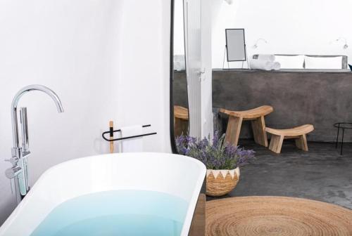 La salle de bains est pourvue d'une baignoire et d'un lavabo. dans l'établissement Luxury Santorini Villa Villa Elysian Dyo Private Hot Tub Air Conditioning 1 Bedroom Oia, à Foinikiá