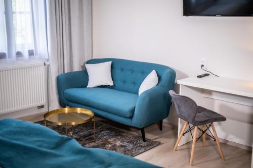 a living room with a blue couch and a table at Boutique Apartments Old Town in České Budějovice
