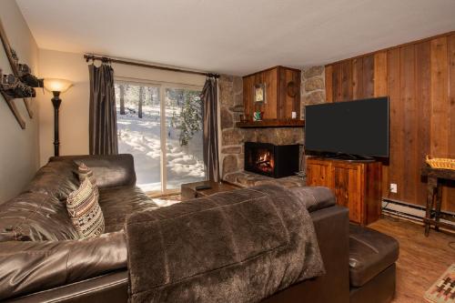 a living room with a leather couch and a fireplace at Beaver Village Unit #0211 in Winter Park