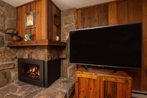 a living room with a television and a fireplace at Beaver Village Unit #0211 in Winter Park