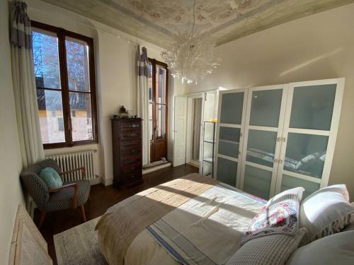 um quarto com uma cama, uma cómoda e janelas em Residenza della Corticella em Verona