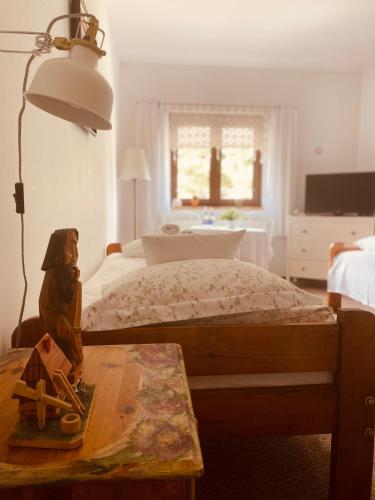 a bedroom with a bed and a table with a lamp at Restauracja Pensjonat Buda in Krosno