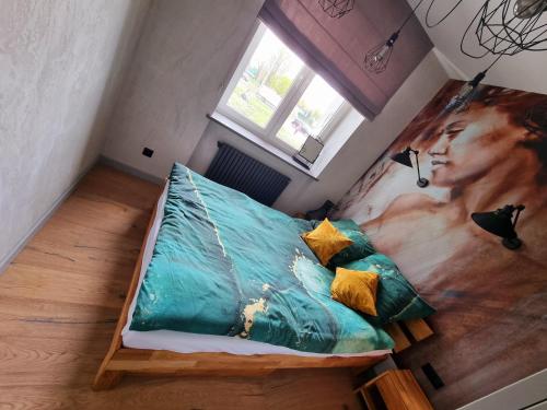 a bedroom with a bed with a painting of a woman at Luksusowy Apartament Przy Sądzie Toruń in Toruń
