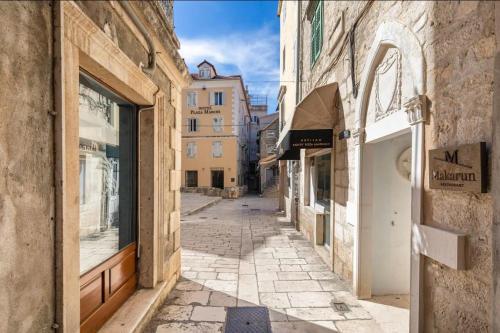 an empty alley in a city with buildings at Luxury rooms Prestige Palace in Split