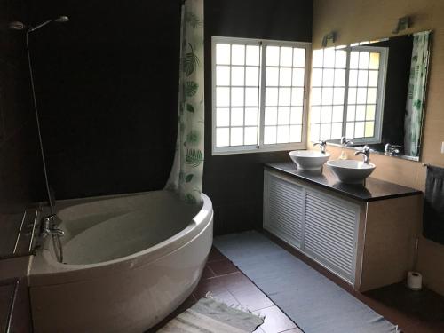 een badkamer met een bad, een wastafel en een bad bij LAVA Açores Coliving & Coworking in Ribeira Grande