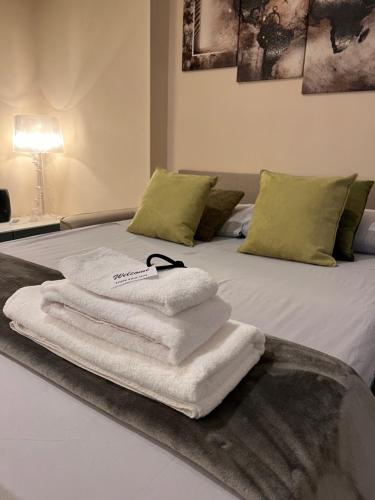 una pila de toallas sentadas encima de una cama en Roma Suite Trastevere Railway Station, en Roma