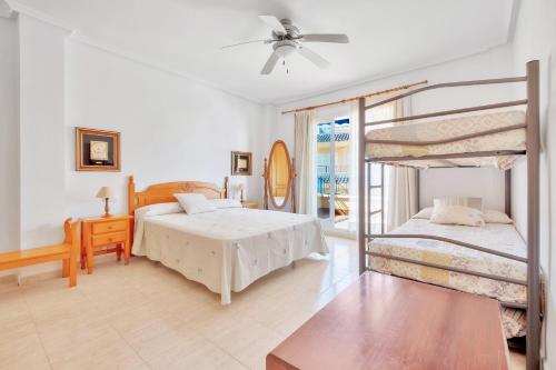 1 dormitorio con 2 literas y balcón en Casa en playa con piscina Novamar, en Santa Pola