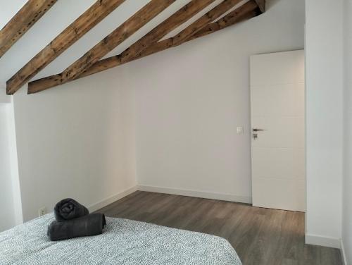 a bedroom with a bed and a white wall at Gran Via 16 Bilbao centro LBI00574 in Bilbao