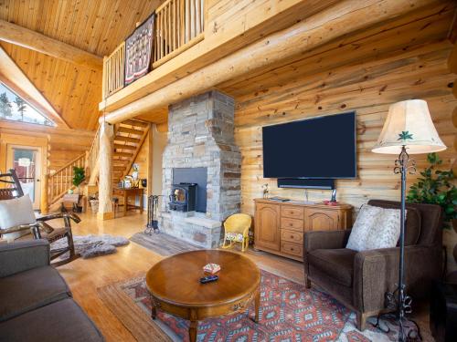 a living room with a fireplace in a log cabin at Miles Behind Log Cabin in Fraser