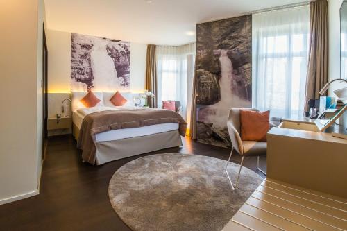 ein Hotelzimmer mit einem Bett und einem Stuhl in der Unterkunft Cascada Boutique Hotel in Luzern