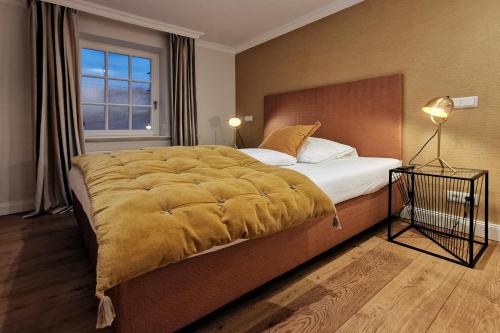 a bedroom with a large bed with a yellow blanket on it at ApartHotel Seepferdchen in Hörnum