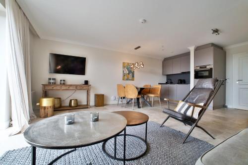 a living room with a table and a kitchen at ApartHotel Seepferdchen in Hörnum