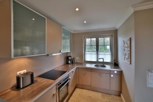 a kitchen with a sink and a counter at ApartHotel Seepferdchen in Hörnum