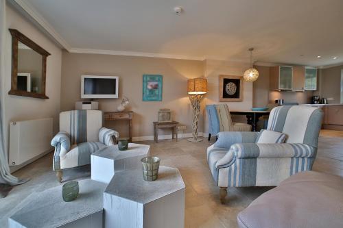 a living room with two couches and a kitchen at ApartHotel Seepferdchen in Hörnum