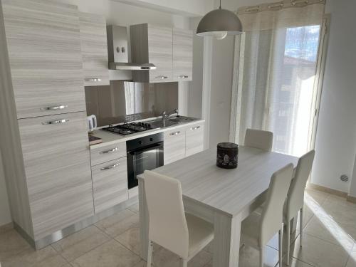 uma cozinha com uma mesa com cadeiras e um fogão em Casa Vacanze Le Tre Scimmiette em Paterno