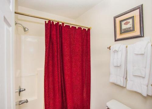 a bathroom with a red shower curtain and towels at Smokin Views Whispering Pines 651 in Pigeon Forge