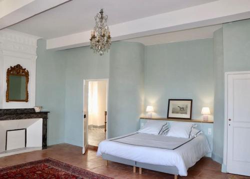 a bedroom with a white bed and a chandelier at Grande villa de vacances avec piscine - 6 chambres in Cesseras