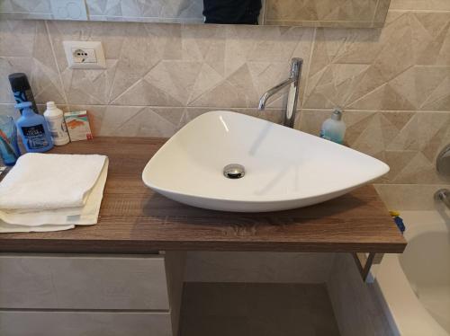 lavabo blanco en una encimera de madera en el baño en Camera doppia privata vicino Milano con bagno in comune, en Concorezzo