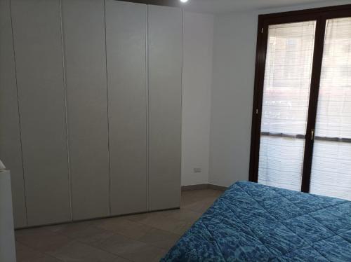 a bedroom with white cabinets and a blue bed at Camera doppia privata vicino Milano con bagno in comune in Concorezzo