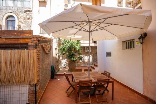 a table and chairs with an umbrella on a patio at Light Garden in Taormina