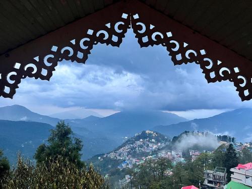 a view of a city from a window with mountains at The Di-Lac Retreat in Gangtok