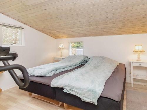 a bed in a room with a wooden ceiling at 7 person holiday home in Højslev-By Traum in Højslev