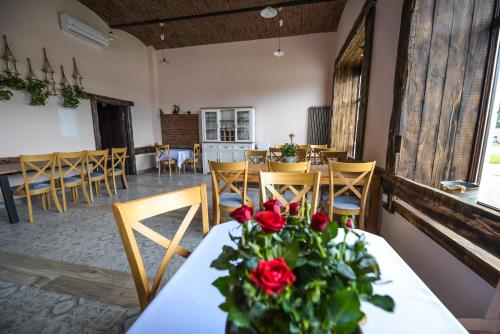 a dining room with a table with roses on it at Willa Zator in Oświęcim