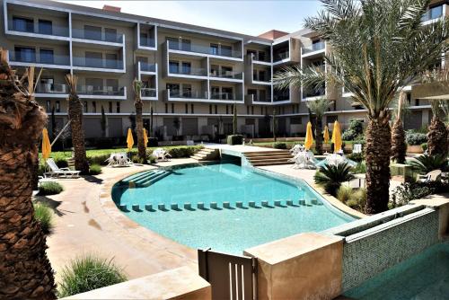un edificio de apartamentos con piscina y palmeras en Royal Deluxe Platinum - Pearl Garden Marrakech, en Marrakech