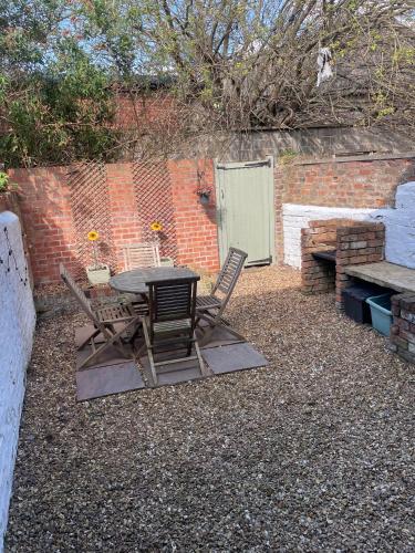 a patio with a table and chairs and a brick wall at Country File in York