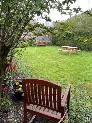 a wooden bench sitting in a yard with a picnic table at Ringfort Manor in Rathfriland