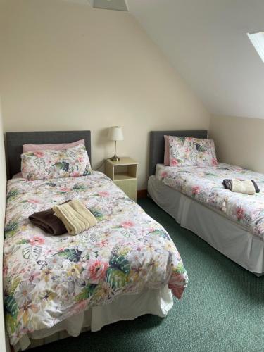 two beds sitting next to each other in a bedroom at Hillside House - Ringfort in Ballinamuck