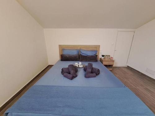 a bedroom with a large blue bed with two chairs at Lydia's cozy house in Paradeísion