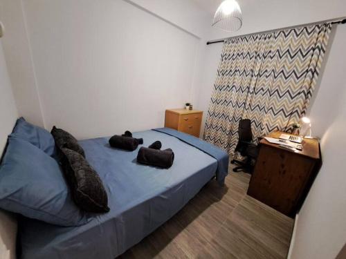 a bedroom with a blue bed and a desk at Lydia's cozy house in Paradeísion