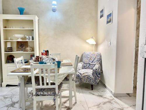 a dining room with a table and a chair at Ortigia Dreaming in Siracusa