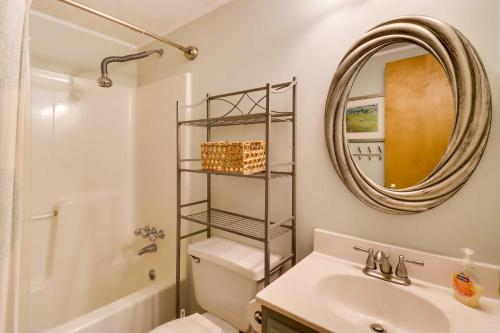 a bathroom with a sink and a toilet and a mirror at Spacious Pocono Lake House Near Skiing and Swimming! in Pocono Lake