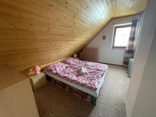 a bedroom with a bed in a wooden wall at Chata Fialka in Veľký Slavkov