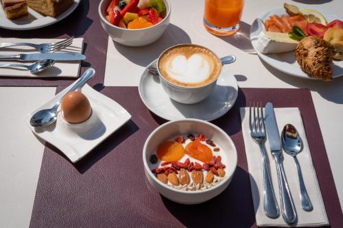 a table topped with bowls of fruit and a cup of coffee at Art Hotel Villa Agape - Place of Charme in Florence