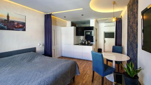 a bedroom with a bed and a table and a kitchen at Studio Bufnița - The Owl's Nest in Sibiu