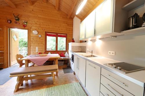 eine Küche mit einem Tisch und einem Esszimmer in der Unterkunft Blockhaus Säuling - Haus Elise Apartments in Füssen