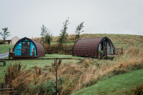 two small domes sitting on a grassy hill at Rossendale Holiday Cottages & Spa in Rossendale