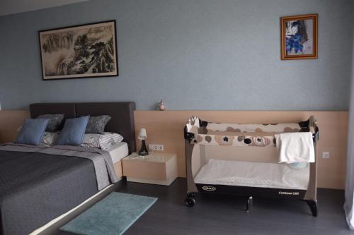 a bedroom with a bed and a baby crib at Panorama Apartman in Velence