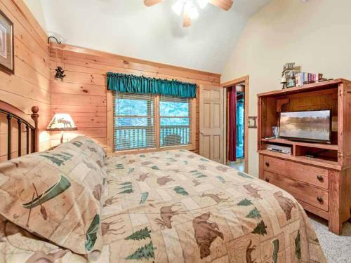 a bedroom with a bed and a flat screen tv at Idle Days, 2 Bedrooms, Sleeps 8, Pool Table, Grill, Pool Access, WiFi in Gatlinburg