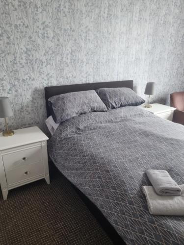 a bedroom with a bed with two night stands and two lamps at Leeds House Guest House in Bridlington