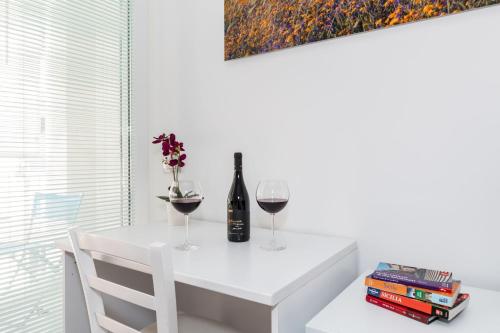 a white dining table with two glasses of wine at B&B Bianco E Blu in Marina di Ragusa