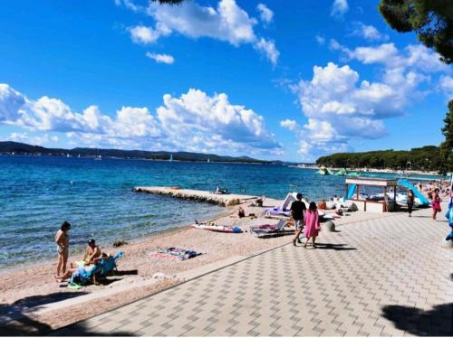 a group of people on a beach near the water at Peponi Del Mar II in Biograd na Moru
