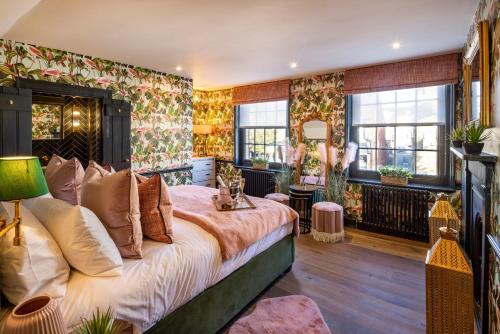um quarto com uma cama grande e papel de parede floral em The Palm Retreat Marlow em Marlow