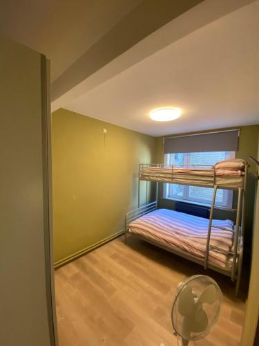 a room with two bunk beds and a fan at Gezellig gezinsappartement. in Blankenberge